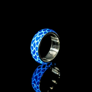 Leuchtender blauer Drachenschuppen-Ring mit Glow-Effekt auf schwarzem Spiegelhintergrund