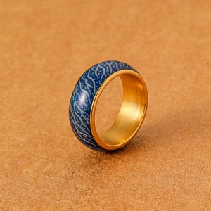 Makroaufnahme des blau leuchtenden Rissmusters auf goldenem Edelstahlring
