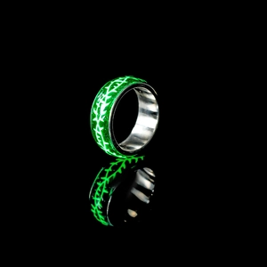 Makro-Detail des leuchtend grünen Dornenmusters auf dem Edelstahl-Ringband