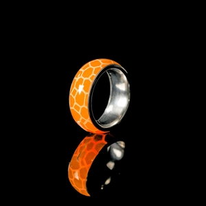 Makroansicht des leuchtend orangefarbenen Rings mit Wabenstruktur und polierter Innenseite