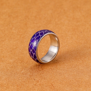 Makroaufnahme: Edelstahlring mit violettem Fischschuppenmuster und blauen Glitzerflocken