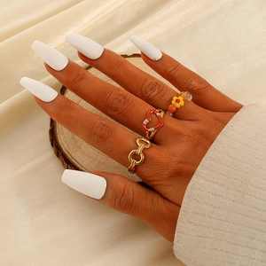 Driedelige set met bloemkralen, hartring en gouden ketting op de hand van het model