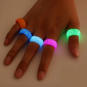 Luminous glow-in-the-dark resin rings set with neon wood grain textures on fingers