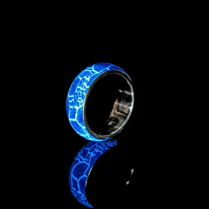 Dettaglio anello luminoso con trama screpolata blu brillante su sfondo scuro