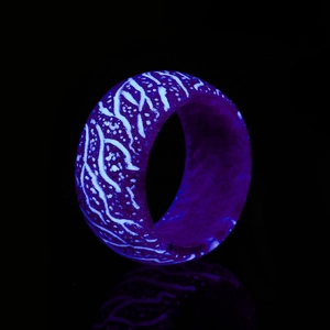 Detail of luminous resin wood grain ring with purple and blue glowing textures