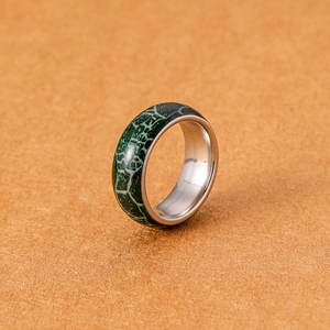 Dettaglio macro dell'anello luminoso da uomo con motivo a coccodrillo verde e acciaio inox