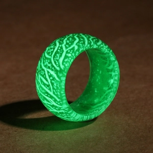 Macro view of luminous resin ring showing vibrant green glow and unique wood vein texture