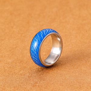 Detailansicht des leuchtend blauen Crackle-Designs und weißen Wellen auf Edelstahlring