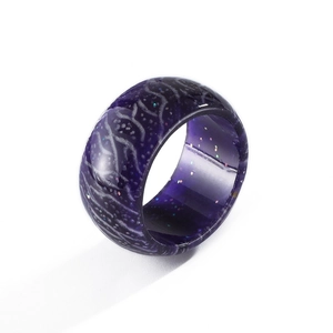 Luminous purple resin ring with wood grain texture and galaxy glitter aesthetic
