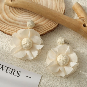 Pendientes bohemios de flores de tela crema con centro de rafia tejida sobre madera