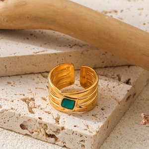 Minimalistischer vergoldeter Ring mit grünem Stein und strukturierter Oberfläche