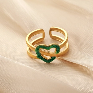 Bague ajustable dorée avec charme coeur vert texturé sur fond satiné élégant