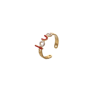 Détail d'une bague dorée LOVE avec émail rouge et blanc et anneau ajouré élégant