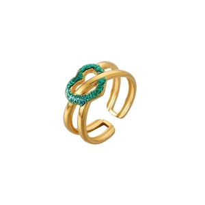 Détail d'une bague ouverte dorée avec un cœur vert texturé et un anneau à double rangée