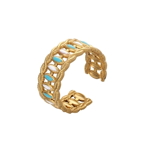 Gros plan détaillé d'une bague dorée réglable avec émail floral bleu clair et blanc