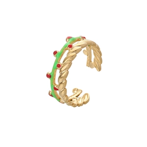 Détail d'une bague torsadée dorée avec vigne en émail vert et points rouges sur blanc