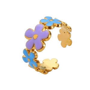 Détail d'une bague ouverte dorée ornée de fleurs en émail violettes et bleues
