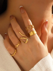 Dettaglio di cinque anelli in acciaio inossidabile placcati oro 18K con texture geometriche