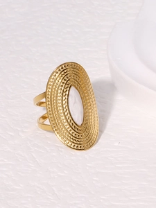 Close-up of gold oval ring with white shell inlay and double-line band detail