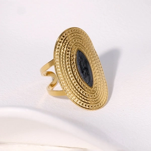 Retro wide gold stainless steel ring with oval relief pattern and black stone inlay