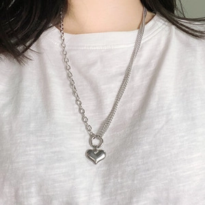 Dettaglio della collana con pendente a cuore d'argento e catena mista asimmetrica