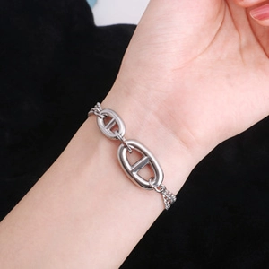 Primo piano di un bracciale a catena d'ancora in acciaio inossidabile lucido sul polso