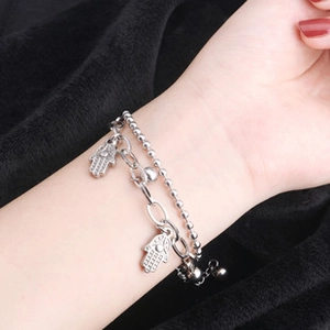 Dettaglio di bracciale a doppio strato argento con ciondoli Mano di Fatima su nero