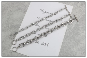 Détail de trois bracelets chaîne punk en acier inoxydable avec fermoir OT de différentes tailles
