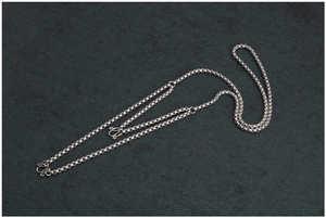 Dettaglio di una catena box in acciaio argento con chiusura a gancio a S su pietra