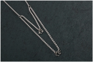 Dettaglio catena box in acciaio inossidabile con chiusure decorative a forma di M argento