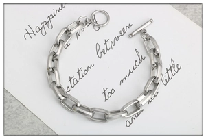 Macro view of silver stainless steel geometric link chain bracelet with a toggle clasp