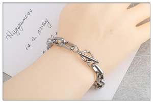 Detailed view of silver stainless steel chain bracelet with OT toggle clasp on a wrist