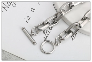 Close-up of geometric stainless steel chain link bracelet featuring a classic OT toggle clasp