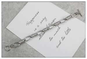 Detail of silver stainless steel chain bracelet with industrial link design and OT toggle clasp