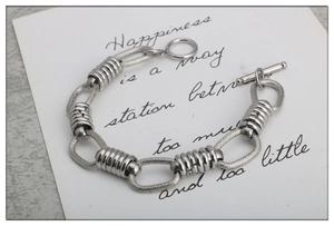 Close-up of stainless steel chain bracelet featuring industrial OT toggle clasp design