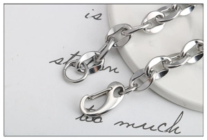Macro di un bracciale a catena spessa in acciaio inossidabile con chiusura a moschettone