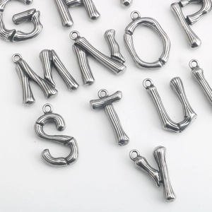 Detailaufnahme der Bambustextur auf Alphabet-Anhängern aus poliertem Edelstahl