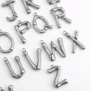 Makroaufnahme von Alphabet-Anhängern mit Bambus-Textur in Vintage-Silber J-Z