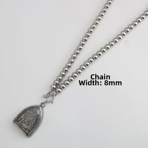 Macro detail of 8mm stainless steel ball chain with an antique silver Buddha pendant