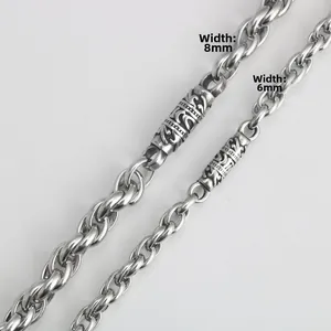 Macro detail of 6mm and 8mm vintage stainless steel necklaces with engraved floral patterns
