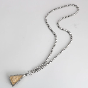Detailed close-up of a silver beaded chain necklace with a triangular religious pendant