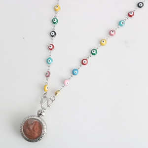 Colorful evil eye beaded necklace with silver Buddha pendant against gray background