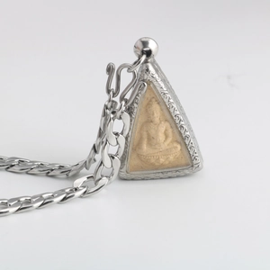 Dettaglio del ciondolo Buddha thailandese con cornice in acciaio e motivi floreali