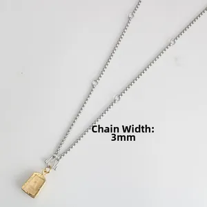 Detailed view of a 3mm wide stainless steel chain with a vintage golden relief pendant