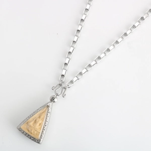 Detailed close-up of a silver stainless steel Thai Buddha pendant on a box chain necklace