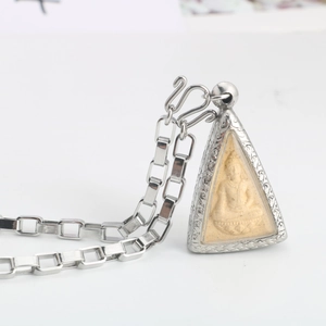 Detail of Thai Buddha amulet with silver metal frame and stainless steel box chain