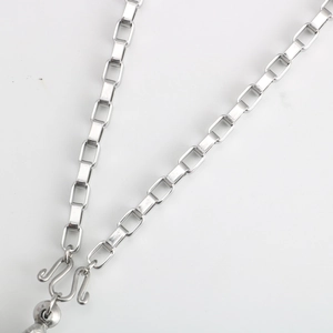 Close-up of stainless steel box chain with dual S-hook clasp and metal bead detail