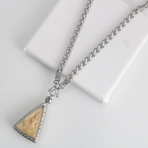 Close-up of a vintage stainless steel keel chain with a carved Buddhist amulet pendant