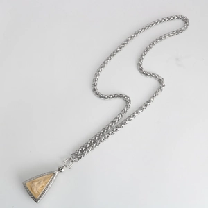 Detail of silver stainless steel keel chain with a triangular Buddha pendant on white surface