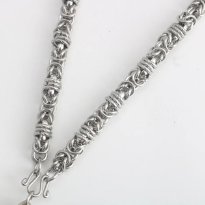 Detailed view of silver braided stainless steel chain with a classic S-hook clasp